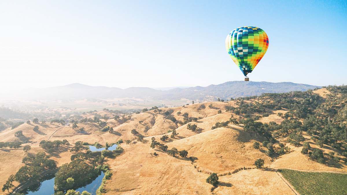 landscape green and orange hot air balloon flying over the mountains balloon